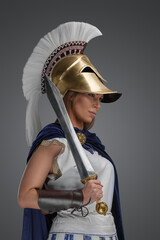 Fototapeta na wymiar Studio shot of ancient greek general dressed in armor and holding gladius.