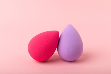 Beauty blender. Colorful beauty sponges on a pink background. Cosmetic tool for applying foundation, concealer. Place for text. Place to copy.