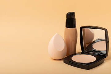Beauty blender for applying bb cream or concealer and cosmetics on a bright colored background. Foundation, face powder, eye shadow, blush and lash mascara. Beauty concept. Fashion. Place for text.