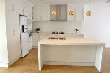 cozinha com ilha branca luxuosa detalhes em dourado 