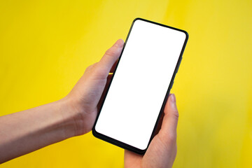 Hand holding phone with blank white screen. Mockup smartphone.