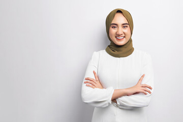 Beautiful smiling friendly young Arabian Asian Muslim woman wearing hijab standing with crossed arms and looking at the camera isolated on white background. People religious lifestyle concept
