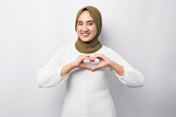 Beautiful smiling friendly young Arabian Asian Muslim woman wearing hijab showing shape heart with hands isolated on white background. People religious lifestyle concept