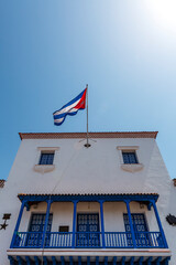 Fototapeta na wymiar Old colonial building with a Cuban flag in the historic center of Santiago de Cuba, Cuba, Caribbean
