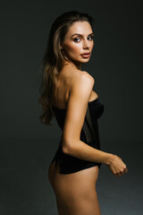 Obraz premium Young and beautiful woman posing in stockings and lingerie over white background