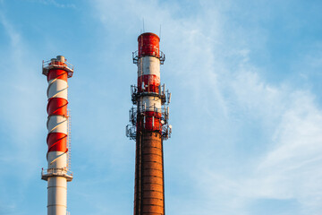 Boiler house chimney. Two towers against the clear blue sky. Industrial zone of the city.