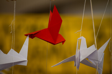 Japanese folded Origami cranes hanging on with strings. Hundreds handmade paper birds isolated with copy space. 1000 thousand crane sculpture topic. Symbol of peace, faith, health, wishes, hope