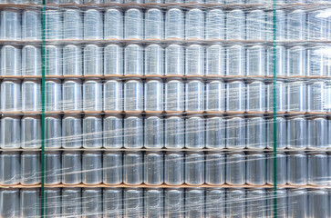Stack of new aluminum cans for cold beverages. Big pallet of metal containers for alcholic and refreshing drinks