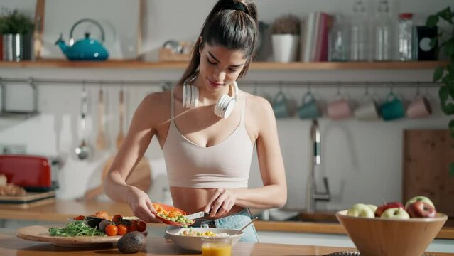 Video of fitness woman making a healthy poke bowl in the kitchen at home.