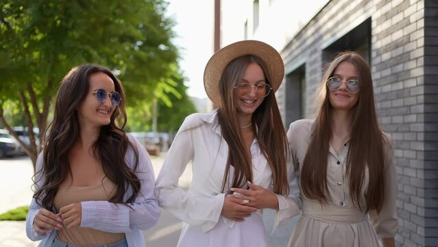 Three young beautiful woman girl female hipster friends in trendy summer clothes walking meeting laughing In street outdoor. Friendship travel. Woman having fun. Concept happiness, freedom, love 