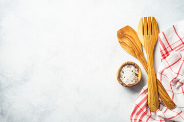 Kitchen utensil, salt and tablecloth on white. Top view with copy space.