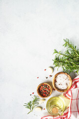 Ingredients for cooking on white kitchen table. Herbs, spices and vegetables. Top view with space for design, vertical.