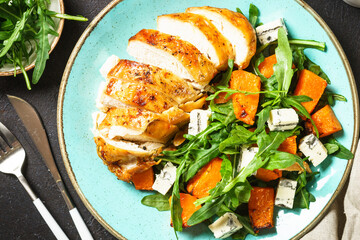 Healthy salad with baked chicken breast, pumpkin, blue cheese and arugula. Healthy diet food.
