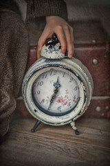 Watch. Antique clock. Vintage watch. Alarm. The boy's hand holds a vintage clock. The clock shows the time.