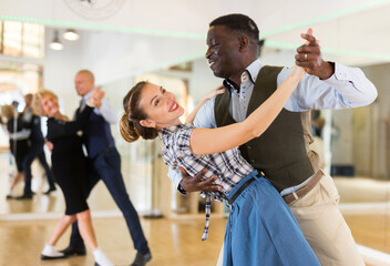 Woman with american man practising ballroom dancing