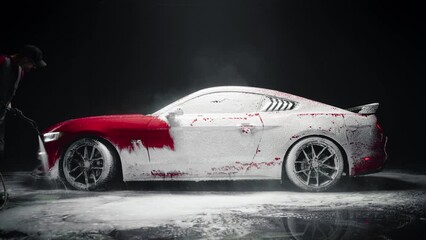 Automotive Detailer Washing Away Smart Soap and Foam with a Water High Pressure Washer. Close Up of a Red Performance Car Getting Care and Treatment at a Professional Vehicle Detailing Shop