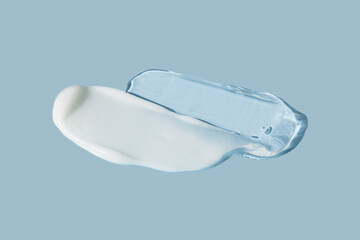 Cream texture. cosmetic cream stroke, face care gel. White cream ant transparent gel smear on blue...