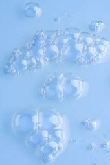 Hyaluronic acid serum texture. Beauty skin care liquid gel background. Clear cosmetic cream with bubbles macro on blue