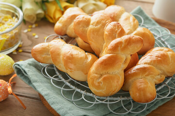 Easter breakfast Holliday concept. Easter bunny buns rolls with cinnamon made from yeast dough with orange glaze, easter decorations, colored eggs on old wooden background. Easter Holliday card.