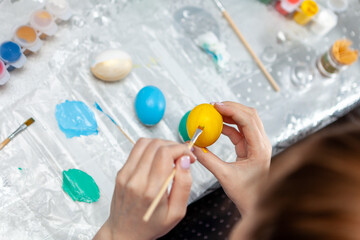 Young pretty woman enjoy painting a water colors on fantasy eggs for Easter egg festival.  The symbolic of Easter egg festival concept