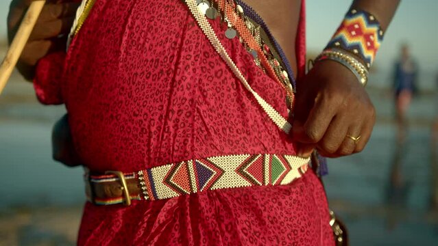 Closeup Details Of Masai Tribe Dressing Accessories With Bold Colors Worn By Male Warrior At The Beach In Watamu, Kenya. ascending reveal