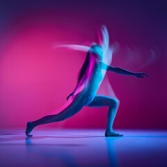 Expressive contemp. Young woman dancing in bodysuit over gradient pink studio background in neon with mixed lights. Concept of contemporary dance style, art, aesthetics, hobby, creative lifestyle