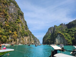 Tourist boats in the blue lagoon among the mountains of Maya Bai island in sunny weather