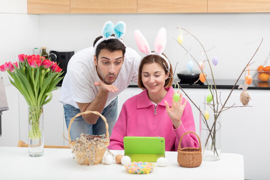 Funny couple wearing bunny ears headband celebrating Easter together at home