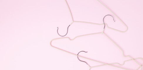 Creative flat lay hangers pastel pink background. Sale discount store promo shopping concept. Top view. Copy space