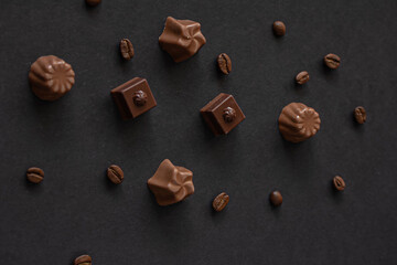 Assorted Chocolates and coffee beans on dark background , top view