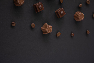 Assorted Chocolates and coffee beans on dark background , top view, copy space