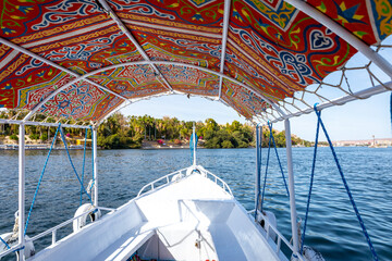 Felucca Sailing on the Nile River in Aswan. Popular Tourist Sailboat in the Nile. Aswan, Egypt....
