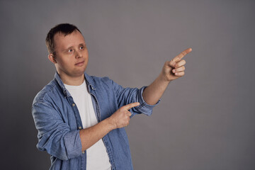 Caucasian man with down syndrome showing on gray background