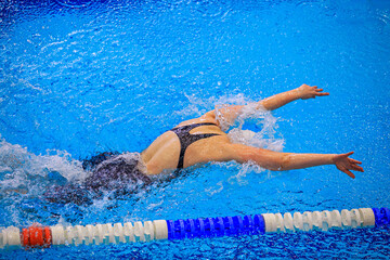 woman athlete swim butterfly stroke in swimming competition