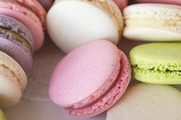 Macaroons in box. French macaroon cake. Sweet macarons or macaroons, flavored cookies are in the paper box. Colorful pink blue yellow green macaron. Sweet macaroons macarons.