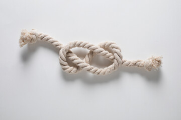 Nautical rope knot on white background, flat lay. Twisted rope cord
