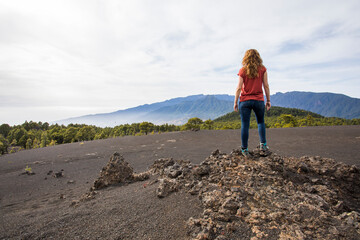 Fototapeta premium Young woman and sunset in Llano del Jable, La Palma, Canary islands.