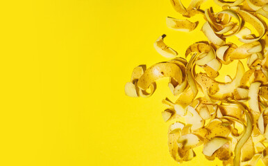 Potato vegetable peels on yellow background. Organic waste,  compost concept. Vegetable scraps to recycling of food waste.