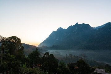 Panoramic view of Doi Luang Chiang Dao, (Doi Chiang Dao) is the third highest peak mountain in Thailand while morning mist flows through the valley area, Chiang Dao District, Chiang Mai, Thailand.