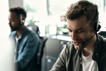 Happy young male customer support executive working in office