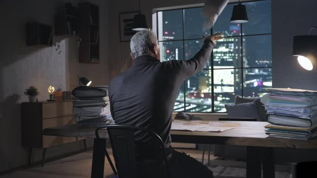 worried man at the desk checking bills gets angry throws papers away,stressed male in home office looking at documents has fit of rage throwing files away,debt bankruptcy household costs concept