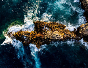 Stormy sea with foamy waves near rocky shore