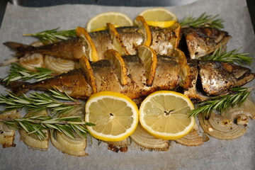 Fish with lemon baked in the oven on an onion pillow. Baked mackerel close-up.