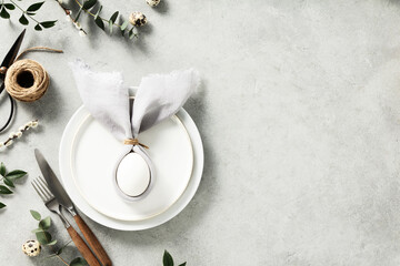 Stylish Easter flat lay, table setting with egg in easter bunny napkin copy space