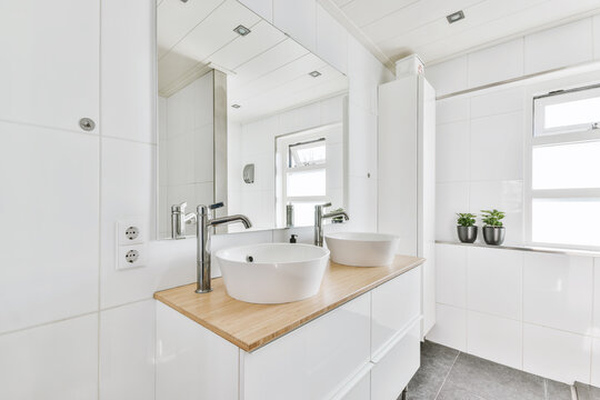 Interior of modern bathroom with white tiled walls