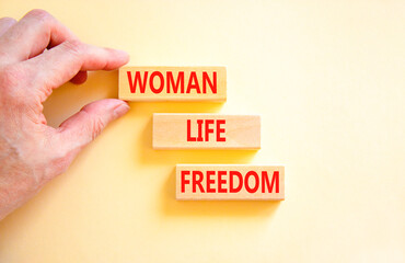Woman life freedom symbol. Concept words Woman Life Freedom on wooden blocks on a beautiful white table white background. Businessman hand. Social issue woman life freedom concept. Copy space.