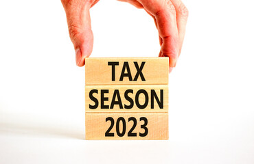 Tax season 2023 symbol. Concept words Tax season 2023 on wooden blocks on a beautiful white table white background. Businessman hand. Business Tax season 2023 concept. Copy space.