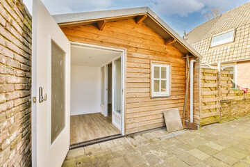 Backyard of wooden cottage with open door
