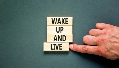 Wake up and live symbol. Concept words Wake up and live on wooden blocks. Beautiful grey table grey...
