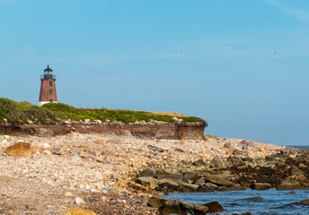 Fototapeta na wymiar Eroded shoreline around the Point Judeth Lighthouse in Narragansett Rhode Island